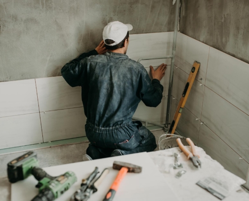 Image of a person installing new tiles in a shower